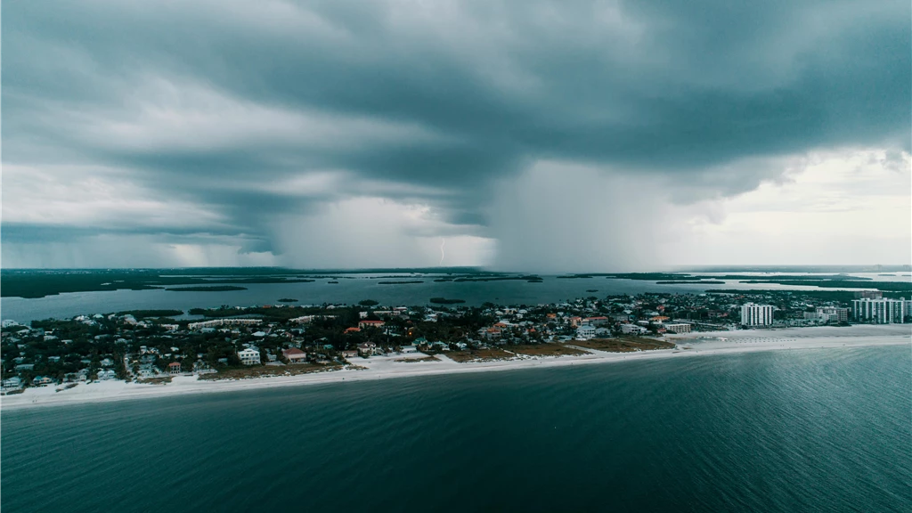 A stunning aerial view capturing a storm approaching an island village along the coast.