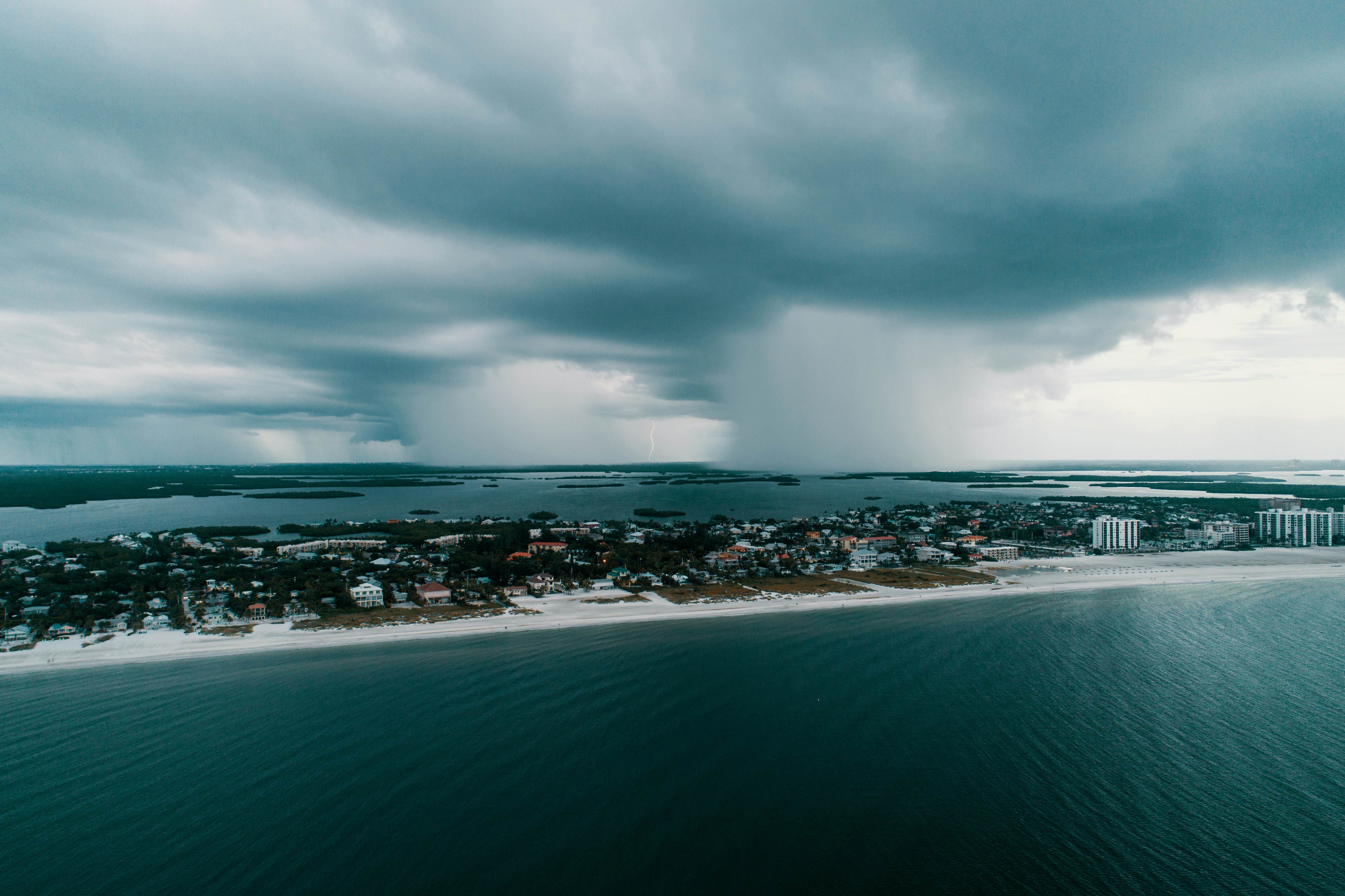 A stunning aerial view capturing a storm approaching an island village along the coast.