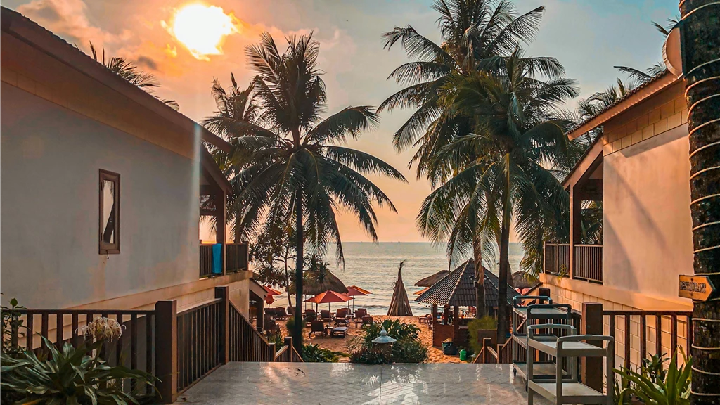 Beautiful sunset over palm-lined beach at Phu Quoc resort, Vietnam, capturing a serene and tropical atmosphere.