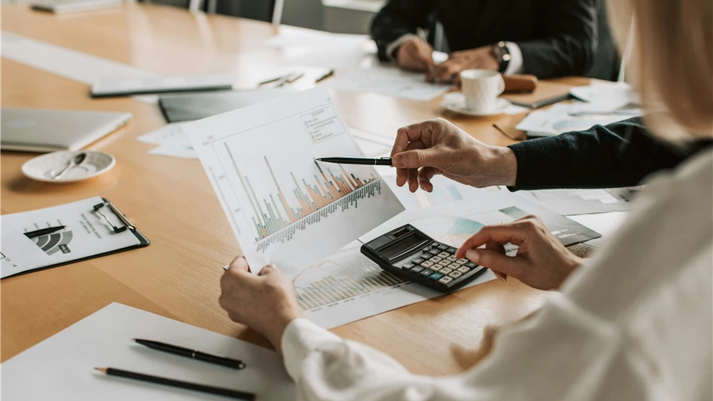 Professionals reviewing financial graphs and charts during a meeting.