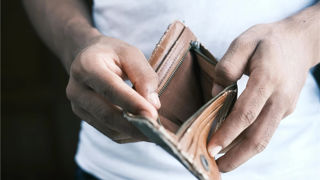 Close-up of hands holding an empty wallet, highlighting financial struggles and economic crisis.