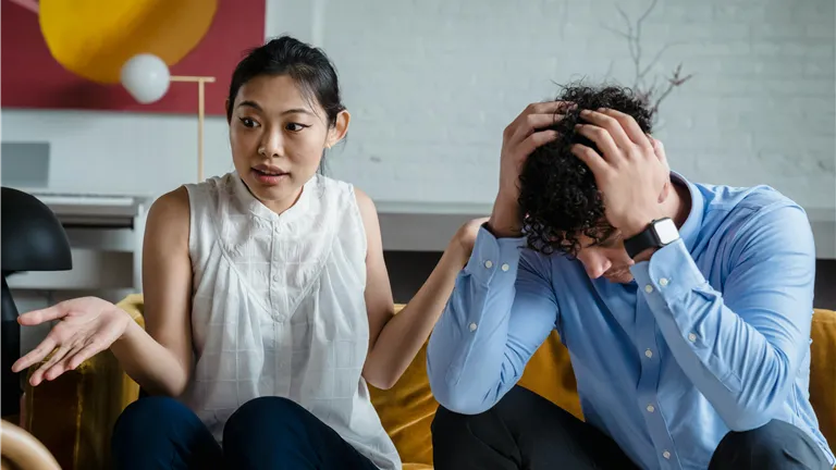 A couple having a serious conversation indoors, expressing emotions and misunderstanding.