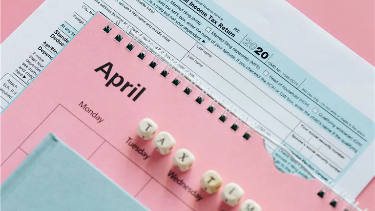 IRS Form 1040 and April planner on pastel background, symbolizing tax season.